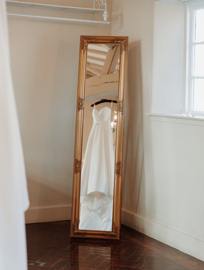 Wedding dress hanging from beam at Offley Place, Hitchin. Wedding Photography by Perfect Memories Photography