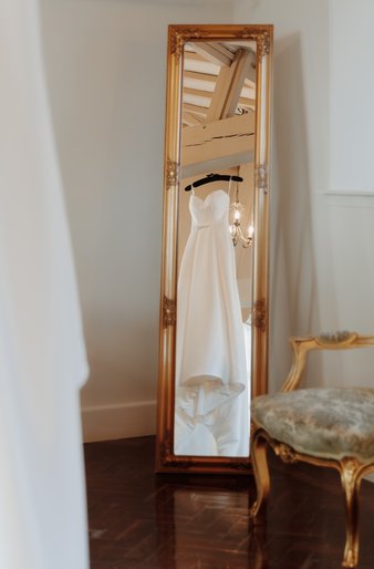 wedding dress hanging from a beam from Pure Couture Beaconsfield wedding at Offley Place