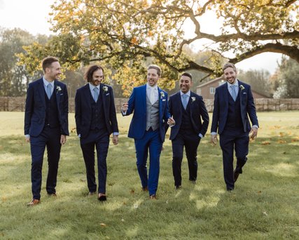 groom and groomsmen walking laughing at offley place wedding hitchin