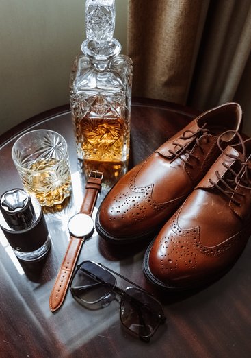 grooms wedding details shoes, watch, glasses, cologne and whiskey