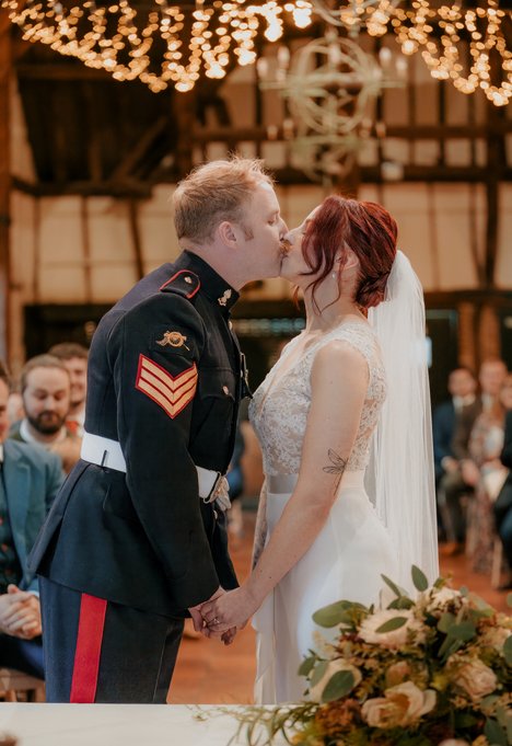 bride and groom first kiss at the tithe barn wedding venue bedford